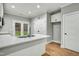 Bright kitchen with white cabinets, quartz countertops, stainless steel sink, and access to the backyard at 507 W Edwards St, Princeton, NC 27569