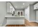 Modern kitchen featuring white cabinets, quartz countertops, stainless steel appliances, and a stylish breakfast bar at 507 W Edwards St, Princeton, NC 27569