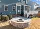 Backyard with a stone firepit, deck, and blue siding on the house at 5121 Windmere Chase Dr, Raleigh, NC 27616