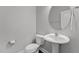Bathroom featuring a toilet and a white pedestal sink with a round mirror at 5121 Windmere Chase Dr, Raleigh, NC 27616
