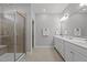 Bathroom featuring double sink vanity, decorative lighting, large mirror, and a tiled shower with glass door at 5121 Windmere Chase Dr, Raleigh, NC 27616