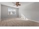 Bright bedroom featuring neutral paint, plush carpeting, a ceiling fan, and a window at 5121 Windmere Chase Dr, Raleigh, NC 27616