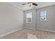 A cozy bedroom with neutral carpet, ceiling fan, and great natural light from two windows at 5121 Windmere Chase Dr, Raleigh, NC 27616