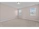 Bright bedroom with carpet flooring and two windows for natural light at 5121 Windmere Chase Dr, Raleigh, NC 27616