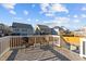 A wood deck with railings overlooks the backyard with seating and a fire pit at 5121 Windmere Chase Dr, Raleigh, NC 27616