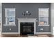 Modern fireplace with white mantel and gray accent wall flanked by two windows at 5121 Windmere Chase Dr, Raleigh, NC 27616