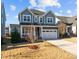 Charming two-story home with a two-car garage, inviting front porch, and manicured lawn at 5121 Windmere Chase Dr, Raleigh, NC 27616