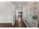 Hallway with hardwood floors and stylish floral wallpaper accent wall at 5121 Windmere Chase Dr, Raleigh, NC 27616