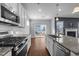 Well-lit kitchen features an island with a sink, stainless appliances, and access to the deck at 5121 Windmere Chase Dr, Raleigh, NC 27616