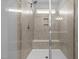 Close-up of a glass enclosed shower with a built-in seat and tiled surround at 5121 Windmere Chase Dr, Raleigh, NC 27616