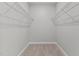 Walk-in closet features neutral paint, plush carpeting, and wire shelving for maximum storage at 5121 Windmere Chase Dr, Raleigh, NC 27616