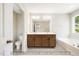 Bathroom featuring a double vanity, large mirror, and tub, offering a blend of style and functionality at 5372 Salem Woods Dr # 18, Graham, NC 27253