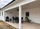 Covered outdoor living area with grill, seating, and view of the lawn at 582 Harnett Central Rd, Fuquay Varina, NC 27526