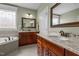 Elegant bathroom featuring double vanities, granite countertops, a soaking tub, and a decorative window at 6205 Roles Saddle Dr, Rolesville, NC 27571