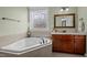 Bathroom with a large soaking tub under a decorative window and a granite vanity at 6205 Roles Saddle Dr, Rolesville, NC 27571