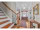 Elegant foyer with hardwood floors, staircase, and natural light streaming through the front door at 6205 Roles Saddle Dr, Rolesville, NC 27571