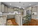 Stylish kitchen with stainless appliances, light gray cabinetry, granite counters, and hardwood floors at 6205 Roles Saddle Dr, Rolesville, NC 27571