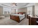 Spacious main bedroom featuring a sleigh bed, tray ceiling, neutral walls, and lots of natural light at 6205 Roles Saddle Dr, Rolesville, NC 27571