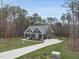 Aerial view of a stunning home with long drive, landscaped yard and surrounded by trees at 85 Willow Bend Dr, Youngsville, NC 27596