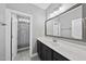 Clean bathroom with dark cabinets, white countertops, a large mirror, and a separate shower at 85 Willow Bend Dr, Youngsville, NC 27596