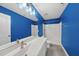 Bathroom featuring a white vanity, large mirror, and blue accent walls at 85 Willow Bend Dr, Youngsville, NC 27596