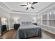 Bedroom has hardwood floors, tray ceiling, fan, and abundant natural light streaming in through large windows at 85 Willow Bend Dr, Youngsville, NC 27596