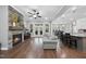 Open-concept living room and kitchen area with stone fireplace, hardwood floors, and a large island with seating at 85 Willow Bend Dr, Youngsville, NC 27596