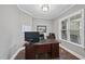 Well-lit home office with a wooden desk, white trim, and a window providing natural light at 85 Willow Bend Dr, Youngsville, NC 27596