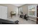 Inviting workout room with exercise bike, TV, bookshelf, and natural light from two windows at 85 Willow Bend Dr, Youngsville, NC 27596
