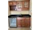 Wet bar featuring granite counters, wine fridge, wood cabinets, and modern fixtures at 101 Tussled Ivy Way, Cary, NC 27513