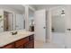 Bathroom with a double vanity, tiled floors, and access to an adjacent bedroom at 101 Tussled Ivy Way, Cary, NC 27513