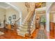 Grand foyer with hardwood floors, a carpeted staircase, and elegant lighting, creating a welcoming first impression at 101 Tussled Ivy Way, Cary, NC 27513
