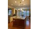 Kitchen island with granite countertops and pendant lighting, opening to a dining area at 101 Tussled Ivy Way, Cary, NC 27513