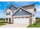 Side view of charming home with stone accents, a two-car garage, and a well manicured lawn at 102 Wilderness Ct, Mebane, NC 27302