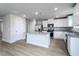 Bright open kitchen boasts white cabinets, granite countertops, and stainless steel appliances at 102 Wilderness Ct, Mebane, NC 27302