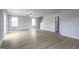 Large living room with light gray walls, wood-look floors, and multiple windows at 102 Wilderness Ct, Mebane, NC 27302