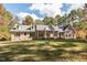 Sprawling brick home boasts a lush lawn, mature trees, dormer windows and bright red front door at 1021 Reaves Dr, Chapel Hill, NC 27516