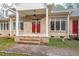 Welcoming covered front porch with double red doors and brick steps at 1021 Reaves Dr, Chapel Hill, NC 27516