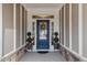 Elegant front door with sidelights, decorative wreath, and manicured potted plants creating a warm welcome at 1024 Traditions Ridge Dr, Wake Forest, NC 27587