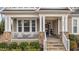 Relaxing front porch with stone accents, white railing, seating, and a welcoming entrance at 1024 Traditions Ridge Dr, Wake Forest, NC 27587