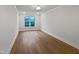Well-lit bedroom with hardwood floors and a large window offering natural light at 10330 Sablewood Dr # 103, Raleigh, NC 27617