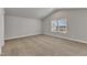 This bedroom has neutral walls and carpet, vaulted ceiling, with a bright window at 104 Wilderness Ct, Mebane, NC 27302