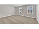 This bedroom features neutral walls and carpet and two bright windows at 104 Wilderness Ct, Mebane, NC 27302