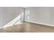 Empty bedroom showcasing light hardwood floors, neutral paint, white trim, and a large window at 104 Wilderness Ct, Mebane, NC 27302
