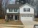 Two-story home featuring stone accents, a two-car garage, black shutters, and a well-manicured lawn at 104 Wilderness Ct, Mebane, NC 27302