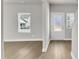 Bright living room features light hardwood floors, neutral walls, and white trim, filled with natural light at 104 Wilderness Ct, Mebane, NC 27302