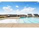 A community swimming pool surrounded by suburban homes under a clear blue sky with scattered clouds at 104 Wilderness Ct, Mebane, NC 27302