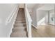 Carpeted staircase with white railing and trim, leading to the upper level with a view of the living room at 104 Wilderness Ct, Mebane, NC 27302