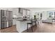 Modern kitchen with stainless steel appliances, island with bar stools, and open living area at 10620 Pleasant Branch Dr # 9, Raleigh, NC 27614
