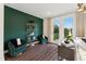 Bright living room featuring dark green accent wall, modern furnishings, and natural light from the large windows at 10622 Pleasant Branch Dr # 8, Raleigh, NC 27614